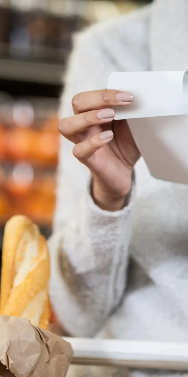 Mid section of woman holding bill