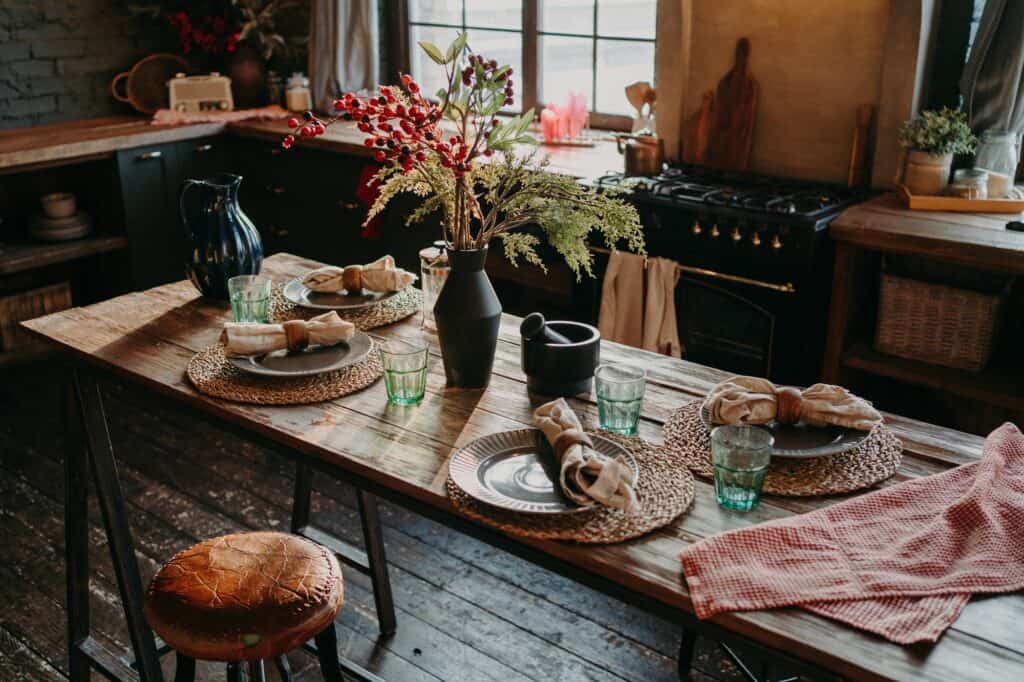 Decorating With What You Already Own: Interior Designers Share Their Best Tips 1 Table served for dinner. Cozy kitchen interior. Cultery and napkins on table for guests decorating with what you already own