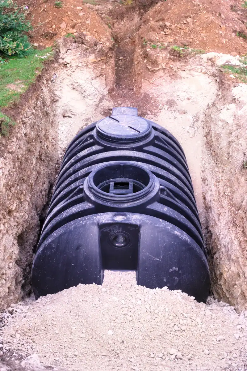 1. Large black septic tank installation in a soil trench for wastewater management.