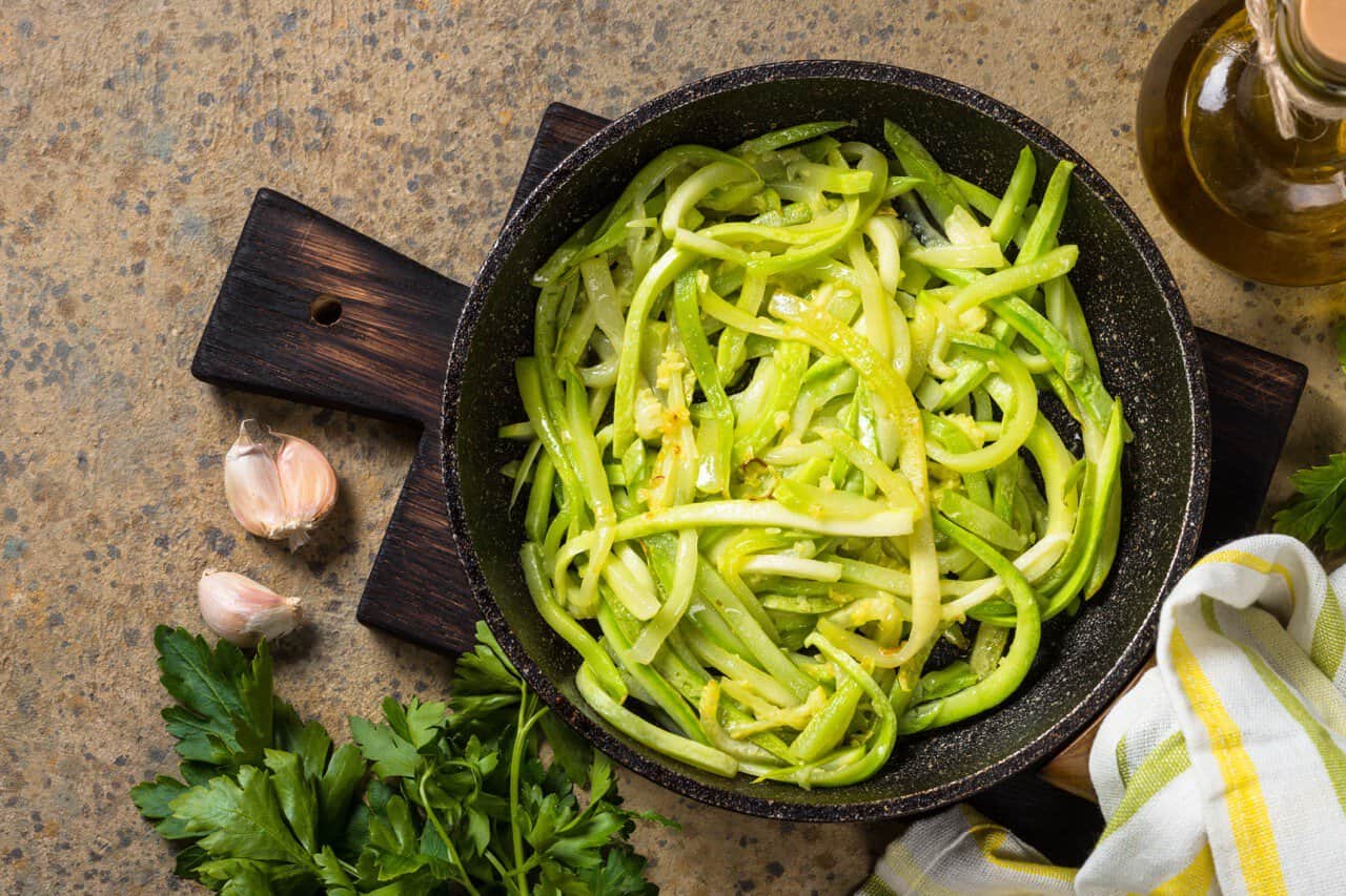 Zucchini cooking in a frying pan.